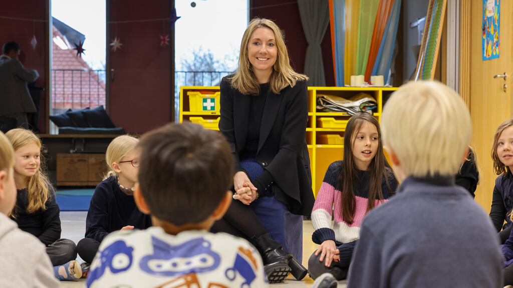 Kultusministerin Anna Stolz im Sitzkreis mit Grundschulkindern